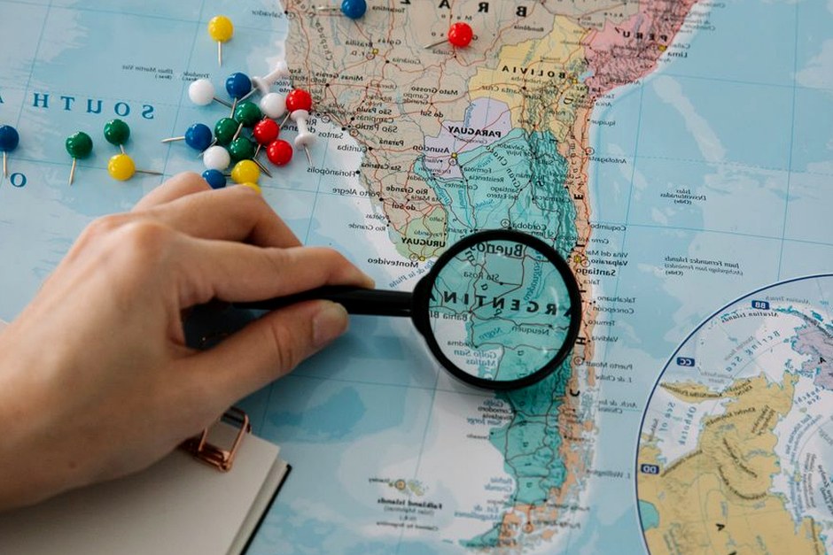 A close view of a map being examined with a magnifying glass.
