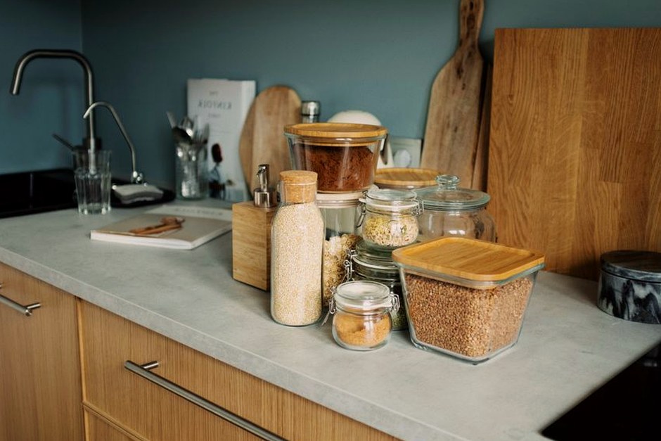 A tidy kitchen counter with jars, cutting boards, and everyday cooking essentials arranged within easy reach.