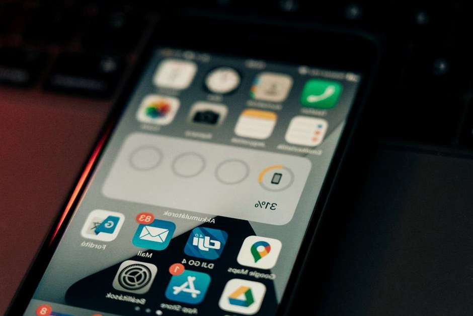 A smartphone resting on a keyboard with a clean view of its app icons and settings.